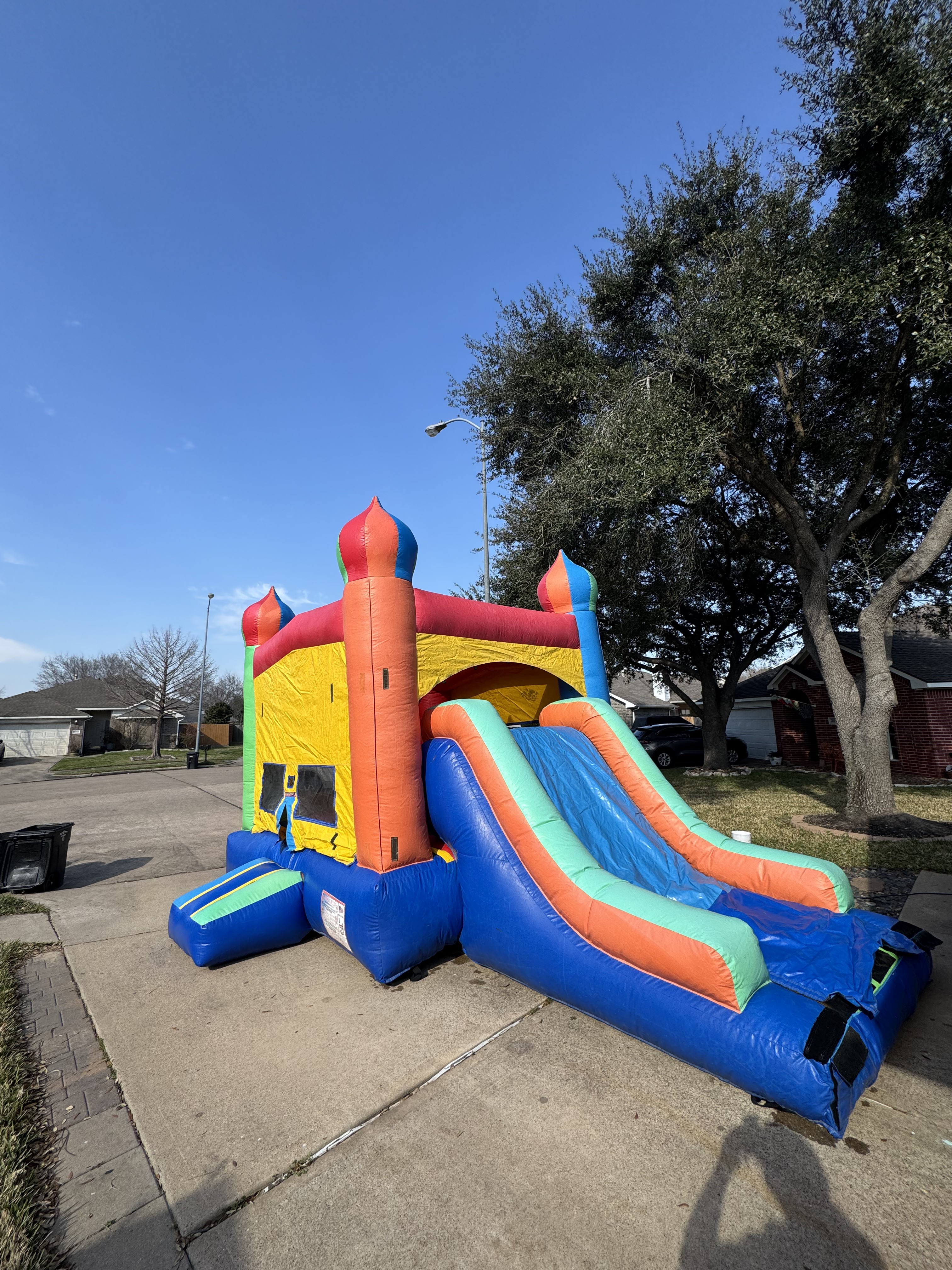 Colorful Katy Jump bounce house and slide set up for a backyard party